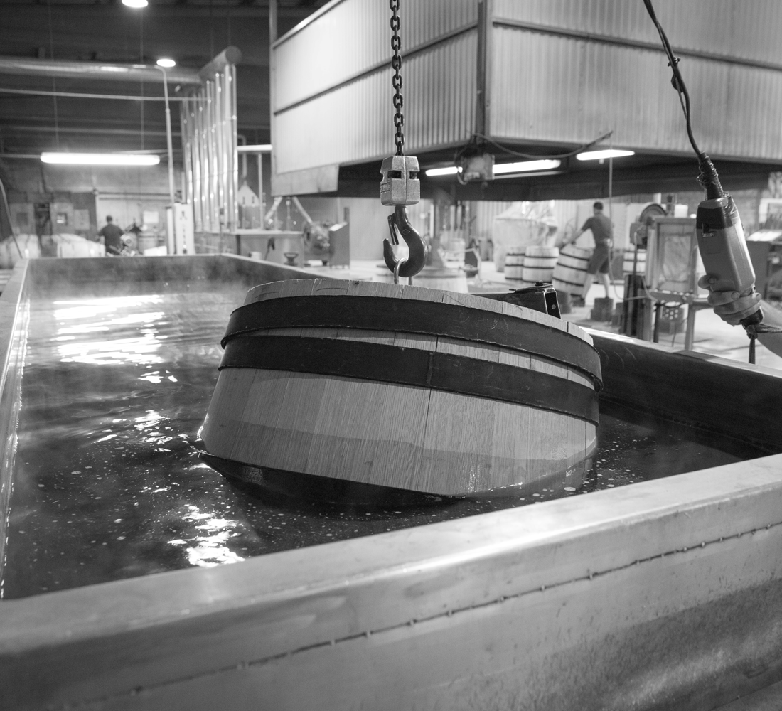 Barrel floating in water with workers in the background working