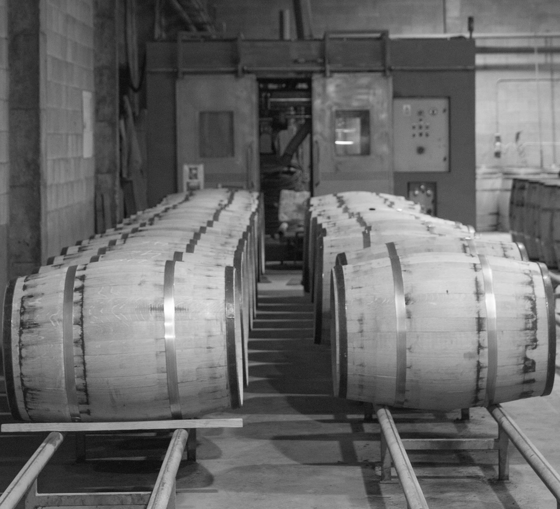 black and white of barrels laying in a factory